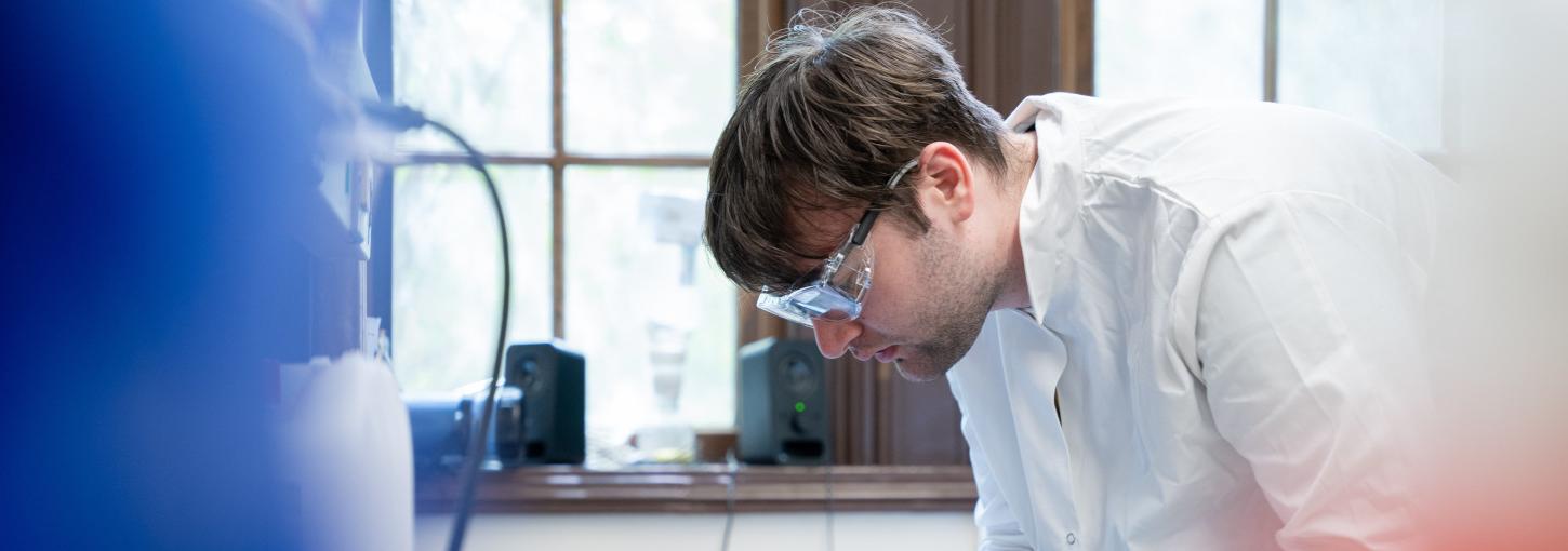 Man wearing lab coat 和 safety glasses